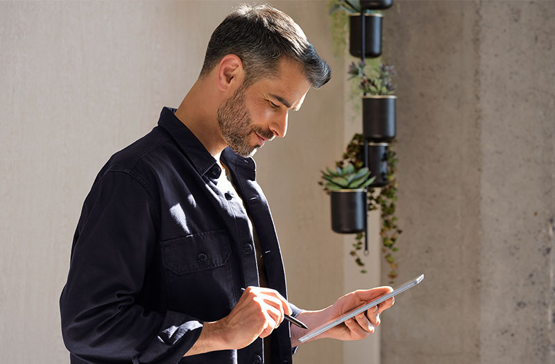 Man working on Microsoft Surface device Man working on Microsoft Surface device