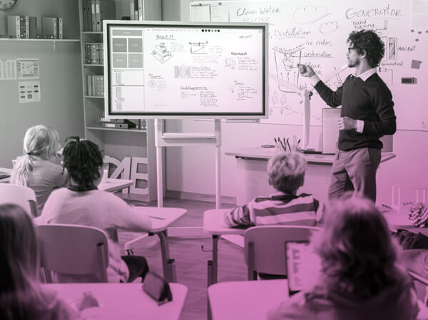 Teacher using large display monitor in classroom with students