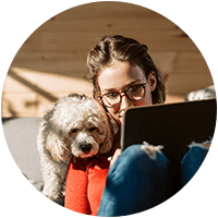 woman using a tablet with her dog