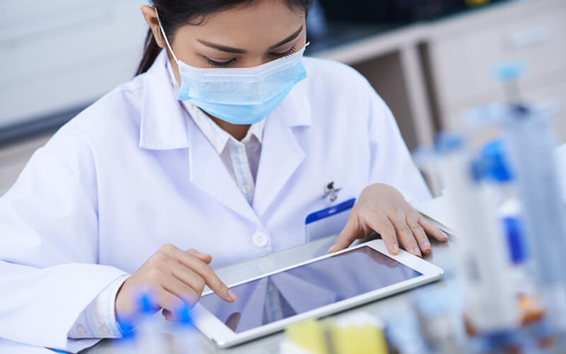 Female scientist works in lab with tablet device