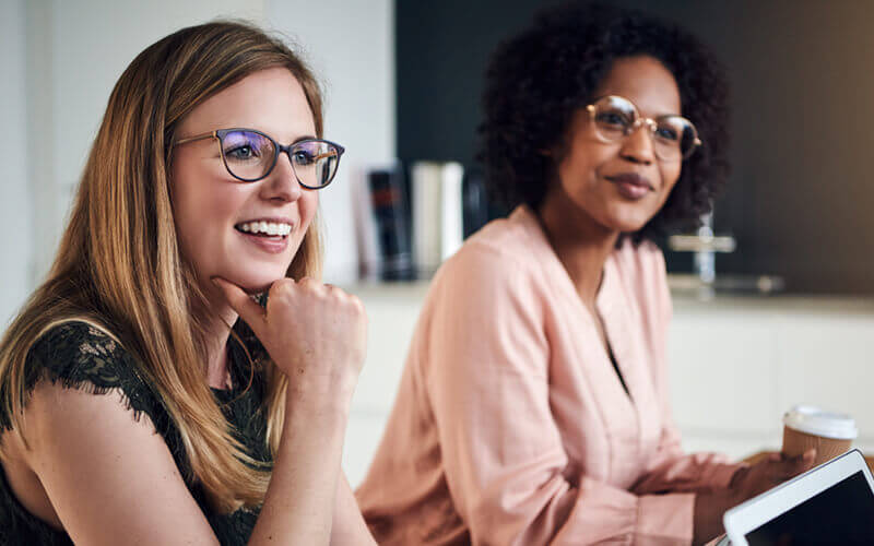 Smiling business women listening in meeting