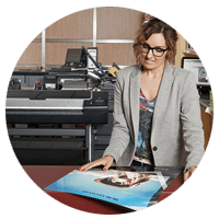 Business woman looks at print from HP Designjet T830 Multifunction Printer