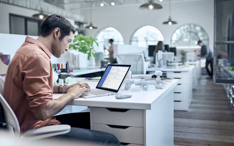 User working on Surface in open office