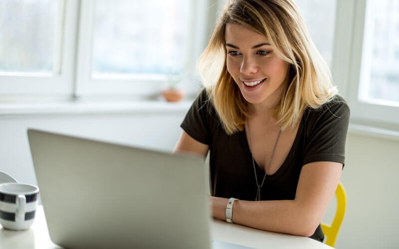 Smiling woman on laptop computer