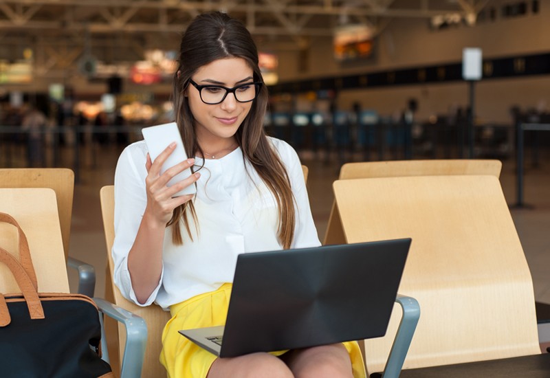 Business woman on phone and laptop in airport