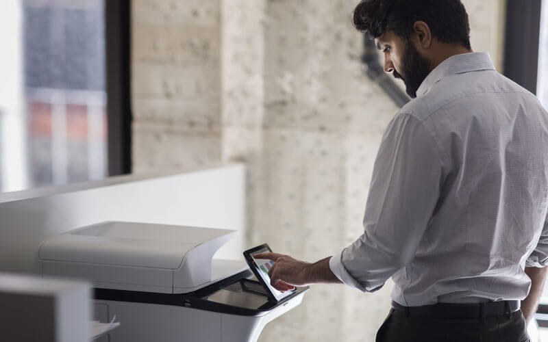 Man using the touch-screen of a HP printer