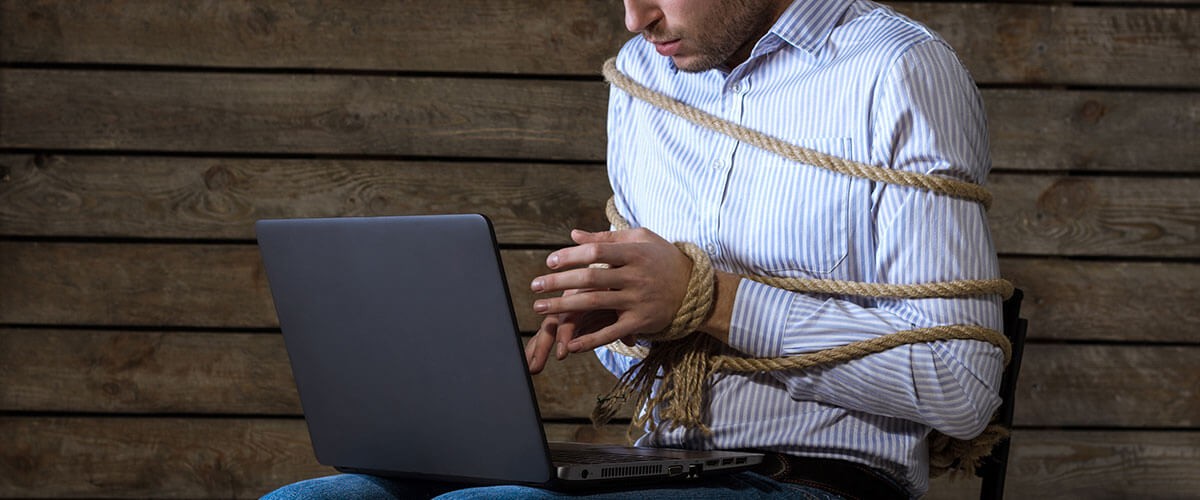 man tied with rope with laptop