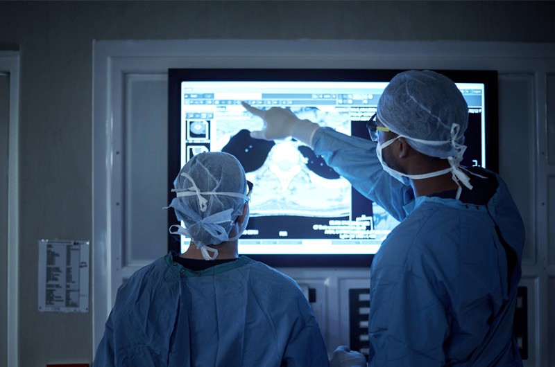 Surgeons using touch screen display to review patient information during surgery