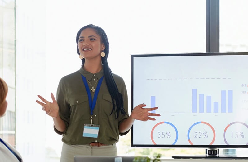 We showcase a growing list of technology events Business woman presenting in front of large flat panel monitor