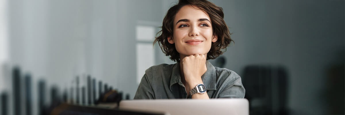 Business woman smiling while working with laptop in modern office. Data protection, data privacy, GDPR, digital, secure, endpoint, user access control