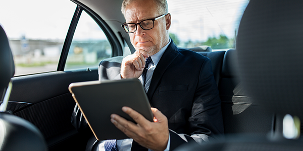 business man using tablet in moving vehicle
