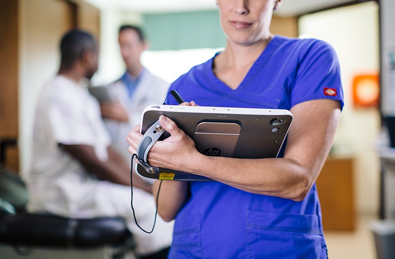 HP solutions for healthcare security challenges Nurse working on patient stats in hospital roo