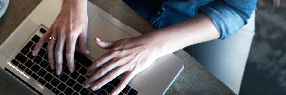 close up of hands typing on laptop keyboard. Apple, Jamf, Mac as a Choice, modernization, device management, end-user support, Mac integration
