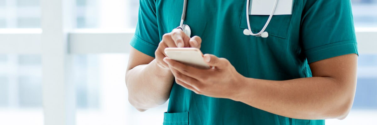 Nurse using mobile device to check on patient and send info to doctor
