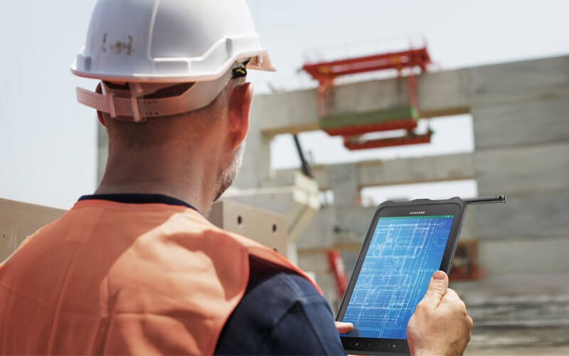 Construction worker on tablet device looking at site
