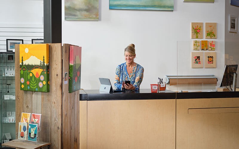 Woman in her art store using Microsoft Surface device
