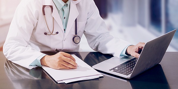 Doctor reviewing patient info securely over SD-WAN network.