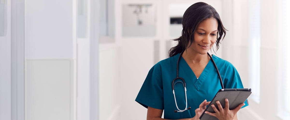 The healthcare sector has to evolve its approach to security to protect against ransomware and cyberattacks. Healthcare professional reviewing patient data securely on mobile device tablet. healthcare cybersecurity practices, security solutions