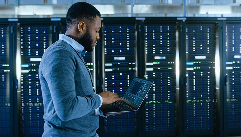 Why NaaS Matters Now More Than Ever Man in IT room on his laptop