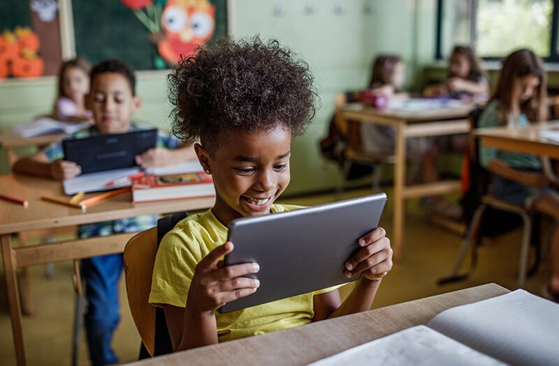 K-12 education contracts Young student using tablet device in classroom