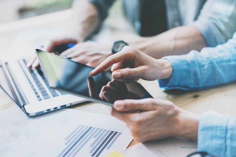 Flexibility of a software-defined architecture Business professionals using multiple mobile devices during meeting