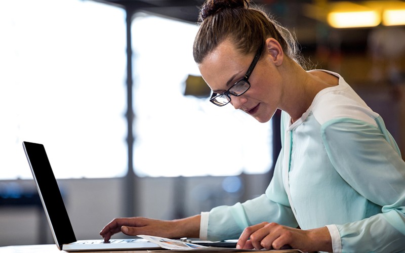 Cloudistics Launchpad Guardian Edition Female employee working on laptop and looking at document