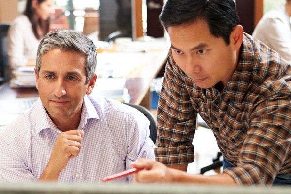 Global knowledge IT training Businessman with pen points at something on computer