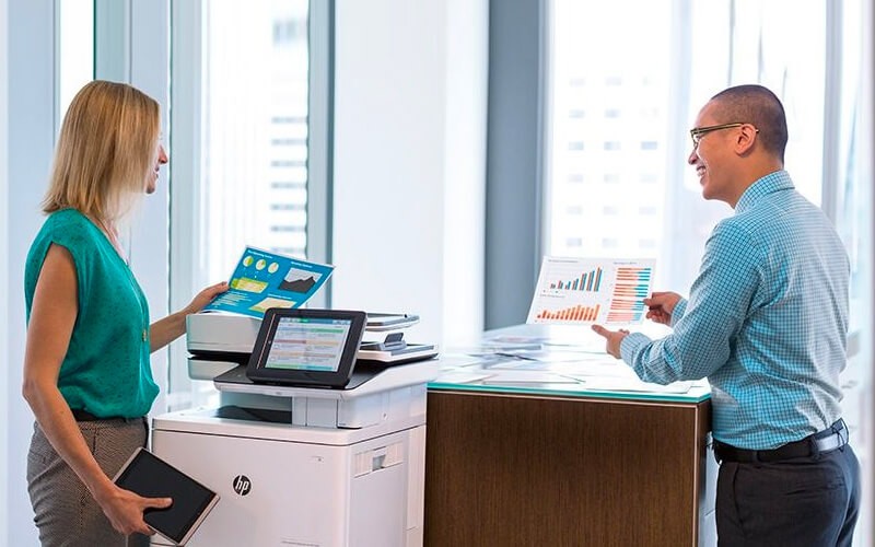 Simplify your billing to a per-cartridge basis and access optional data collection software Two colleagues talking to each other while using HP printer