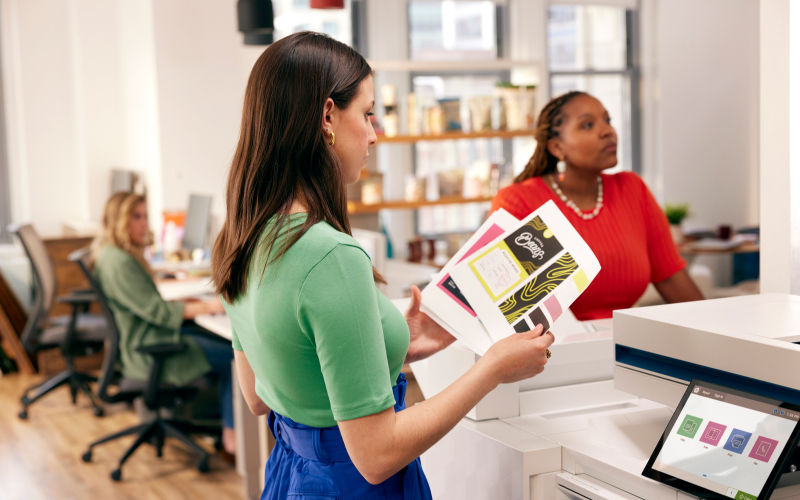 The world’s most secure printers woman holding freshly printed papers from an HP printer