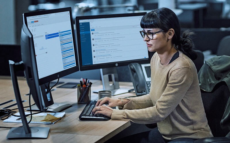 Hardware-enforced security Woman with glasses working using a HP computer at the office