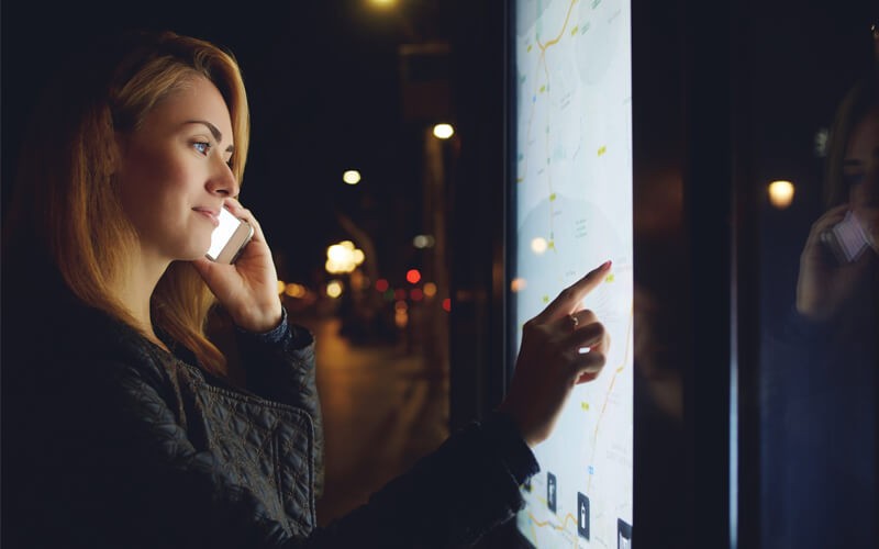 Woman using digital sign at night