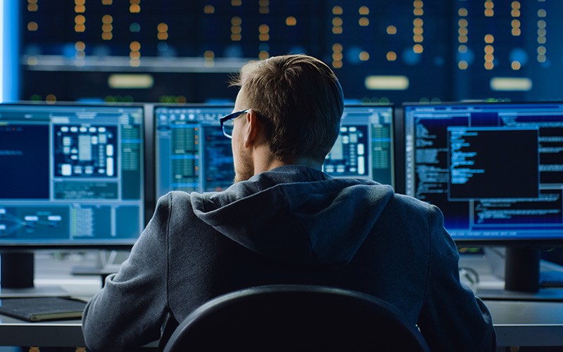 Strengthen your cyber resilience and data security with Micro Focus IT professional working on his desktop