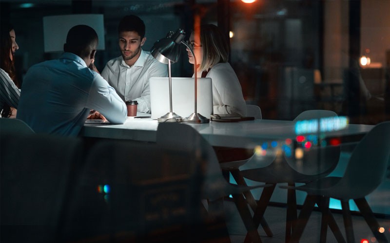 Group of employees working in office at night