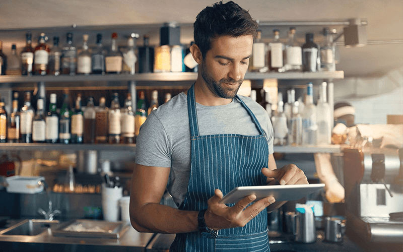 Friction-less contact center journey Man in apron using a tablet