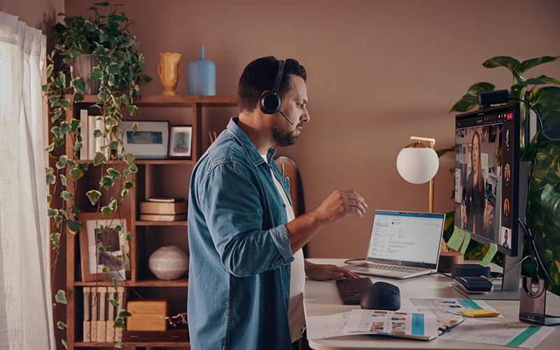 Poly headsets and speakerphones fuel clear, distraction-free conversations Business man using Polycom phone