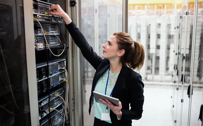 uest database management software tools Woman looking in data center