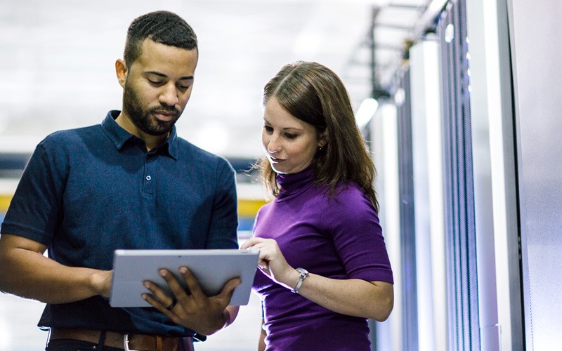 Scale to the cloud in a simple, affordable way IT admin with business professional touching tablet in data center