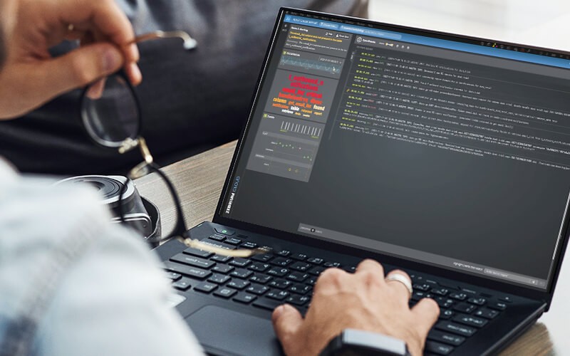 Prevent costly outages with Zebrium. Person using a laptop at work