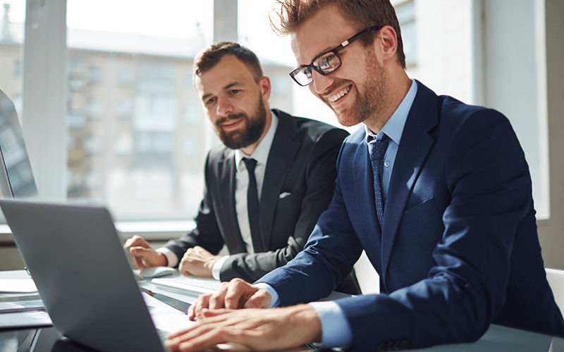 Achieve stronger cybersecurity outcomes Two colleagues talking to each other