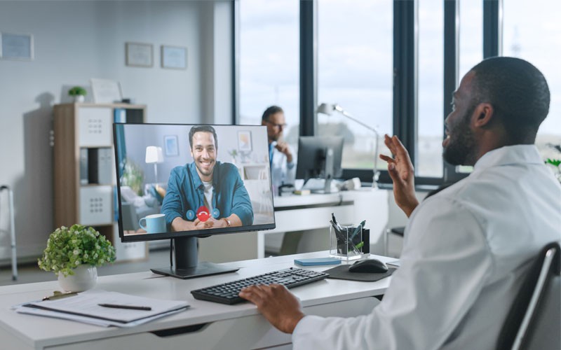 Have the confidence to tackle your ambitious IT challenges Doctor using computer in telehealth consultation