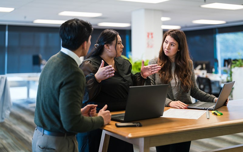 teammates-collaborating-in-office-table-discussing teammates-collaborating-in-office-table-discussing