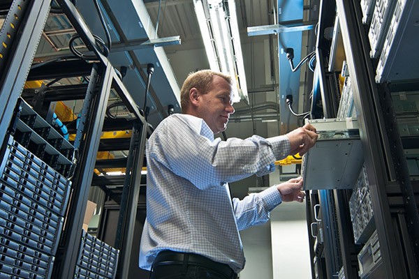 IT technician replaces server in data center